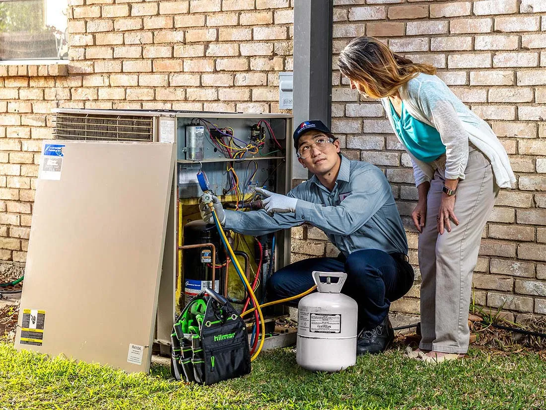 Service Experts technician showing a customer the inside of an air conditioner