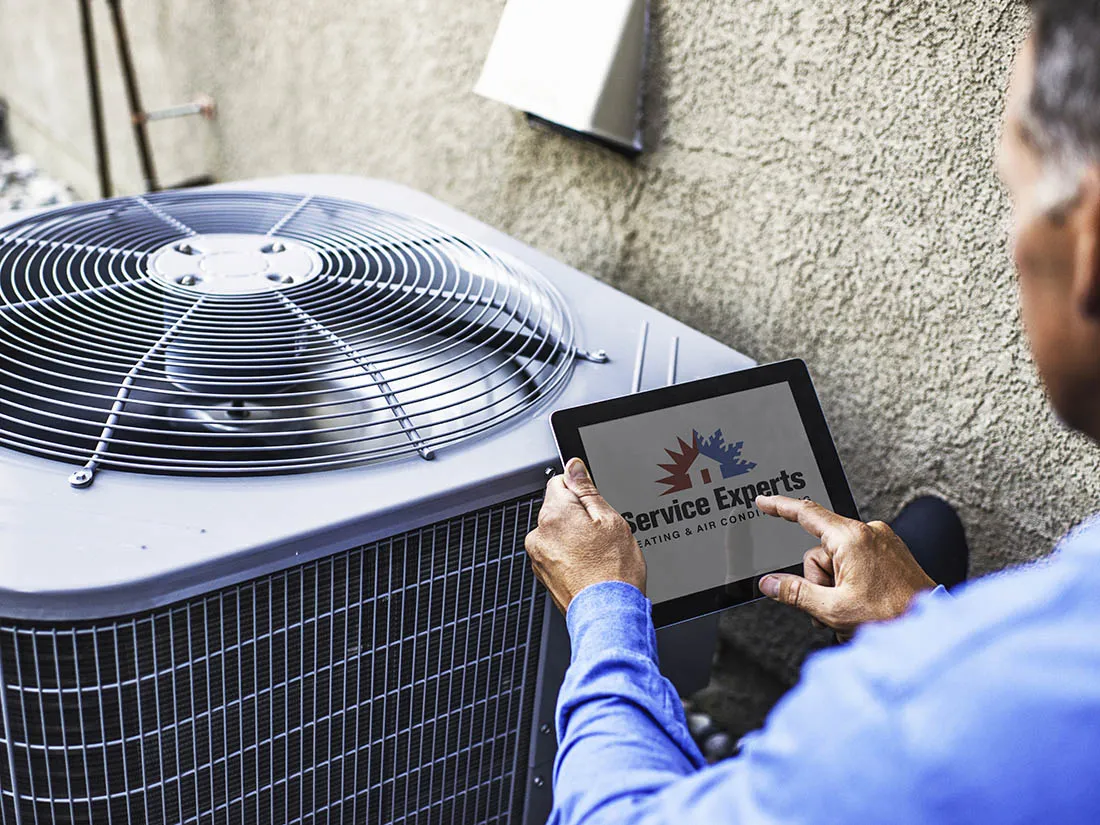 Maintenance engineer using digital tablet to inspect heat pump unit